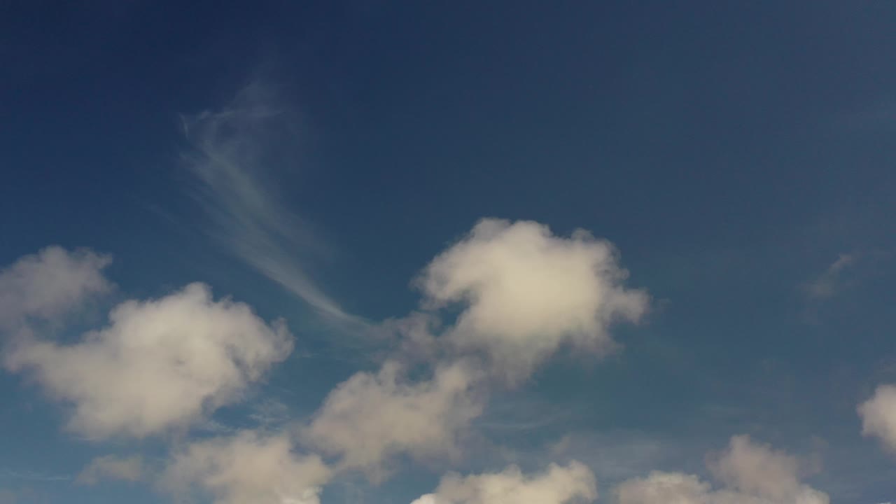 Blue sky with white clouds and a wispy diagonal cloud band.