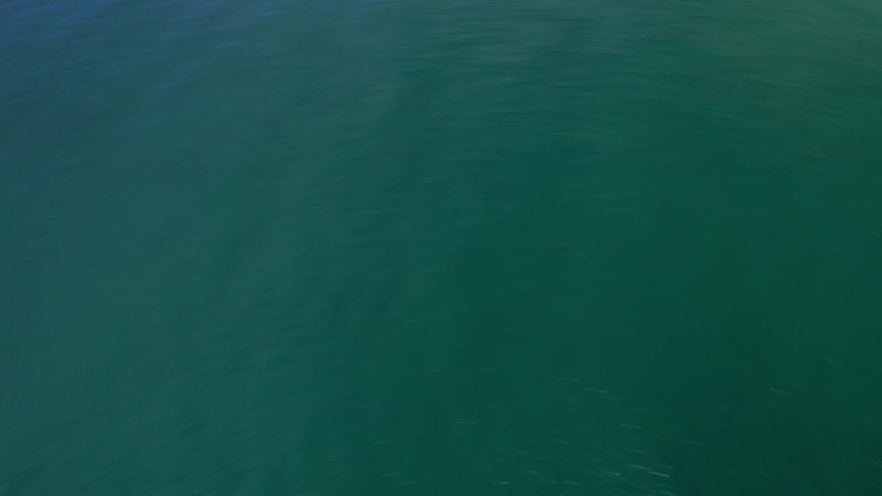 Aquamarine water with a faint white wave crest near the top