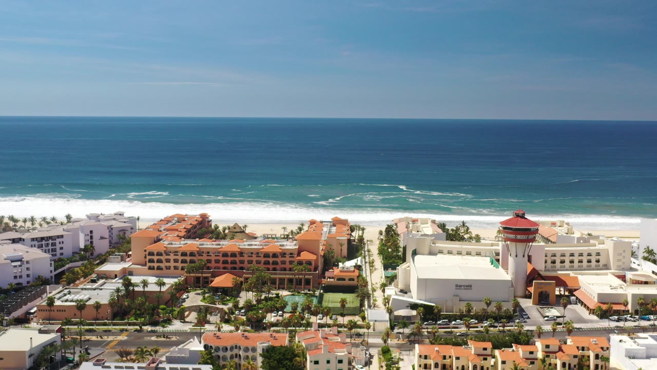 Aerial view of beachfront buildings beside a blue ocean.