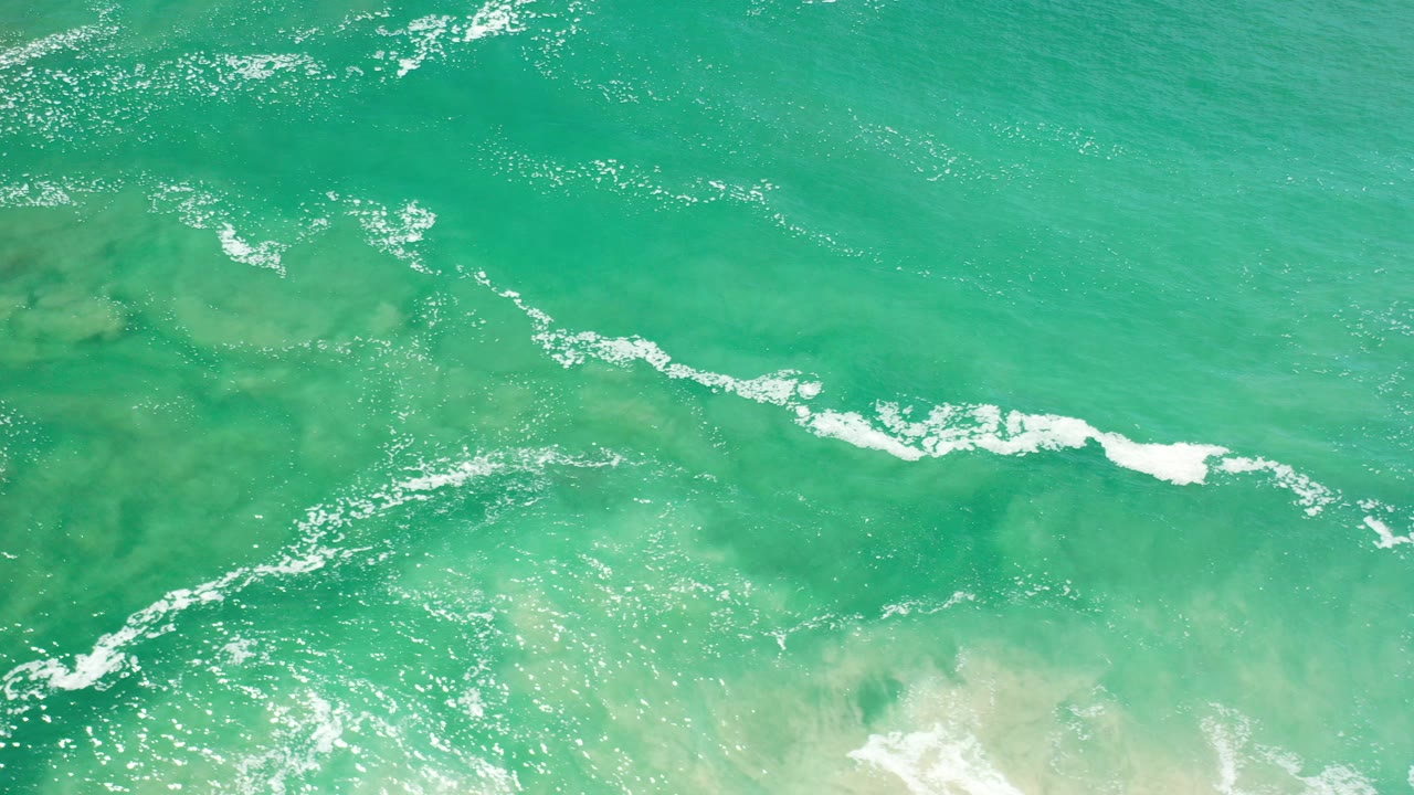 Overhead turquoise ocean with white foam streaks