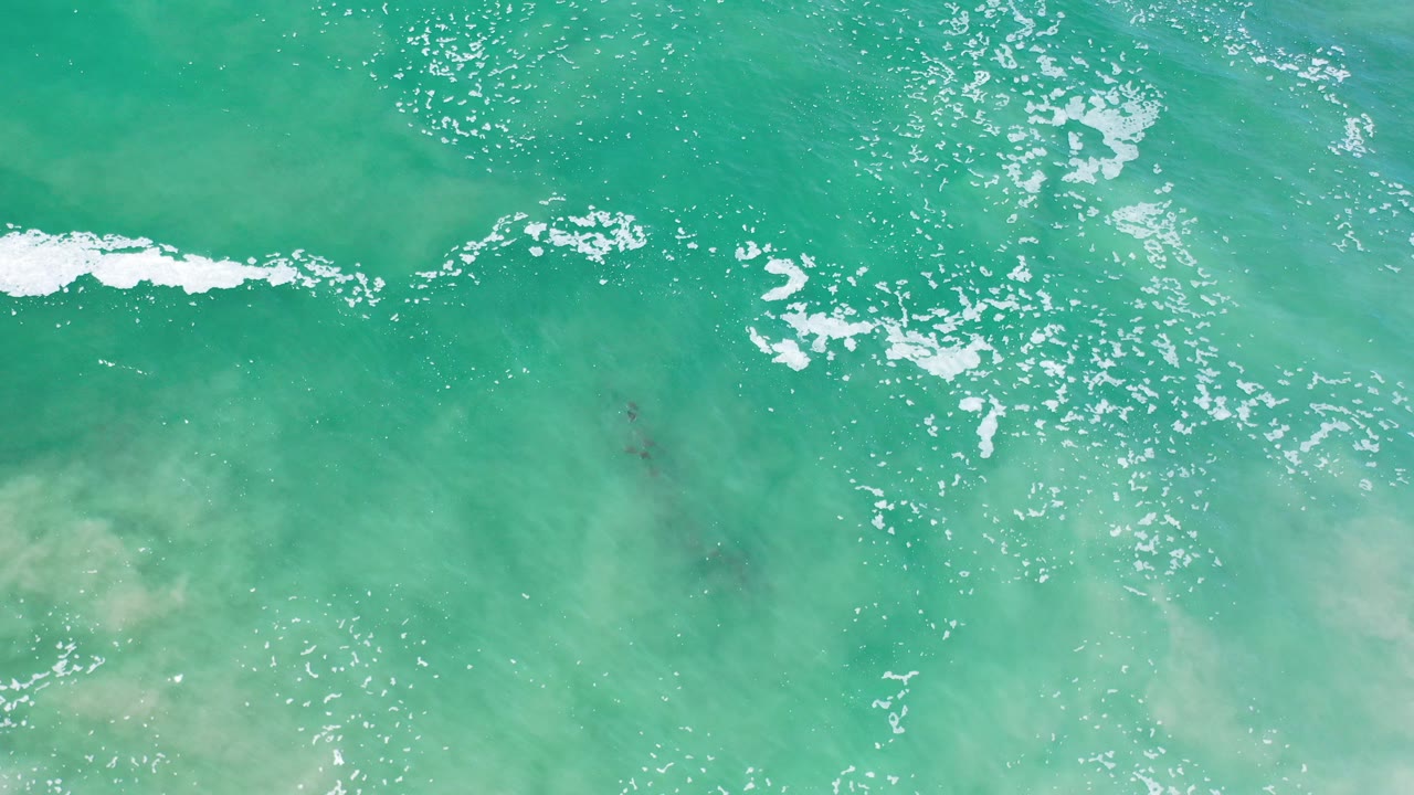 Overhead turquoise ocean water with white foam streaks.
