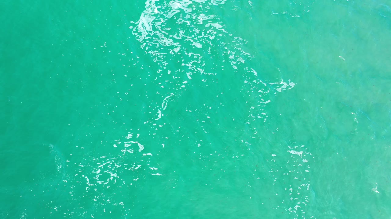 Clear turquoise water with bright rippled highlights.