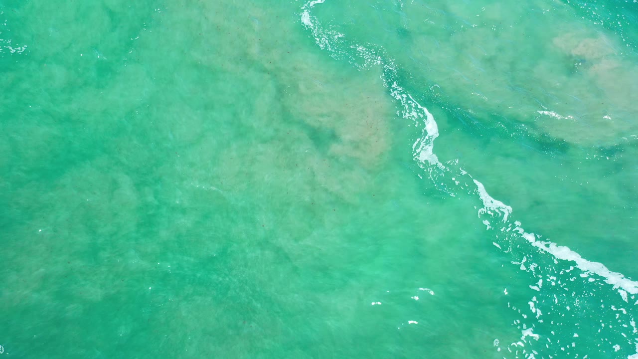 Aerial water view with teal surface and pale underwater patches