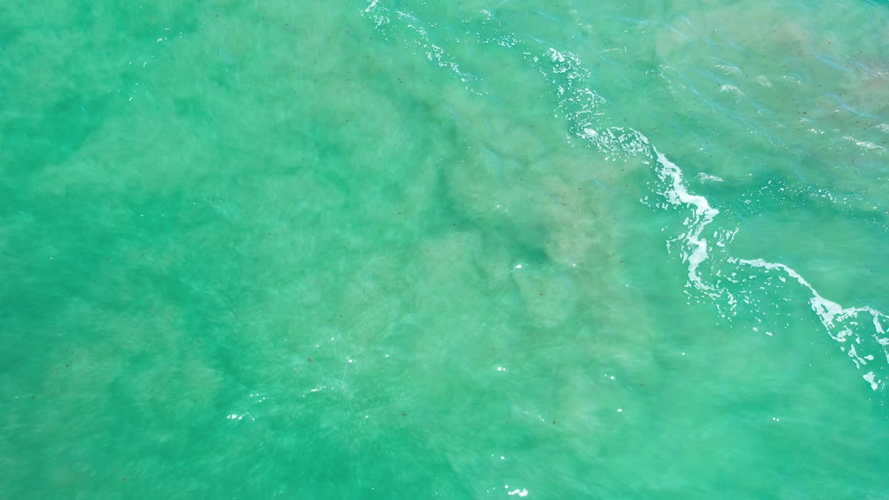 Overhead turquoise water with white foam angled across the upper right area.