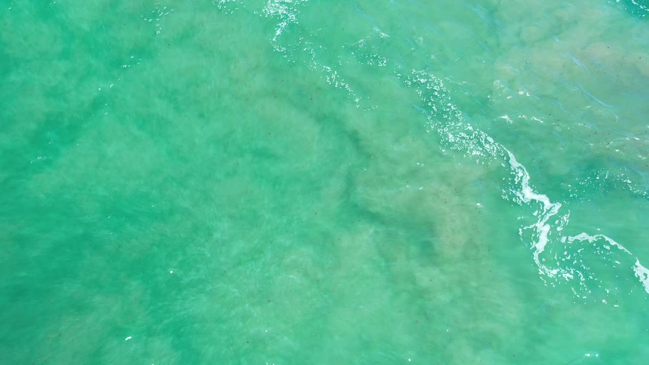 Aerial green water texture with scattered white highlights and foam.