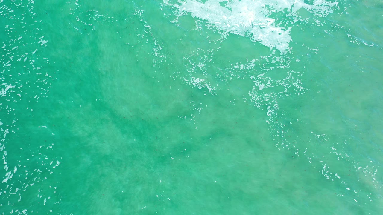 Turquoise ocean water with white foam near the top edge.