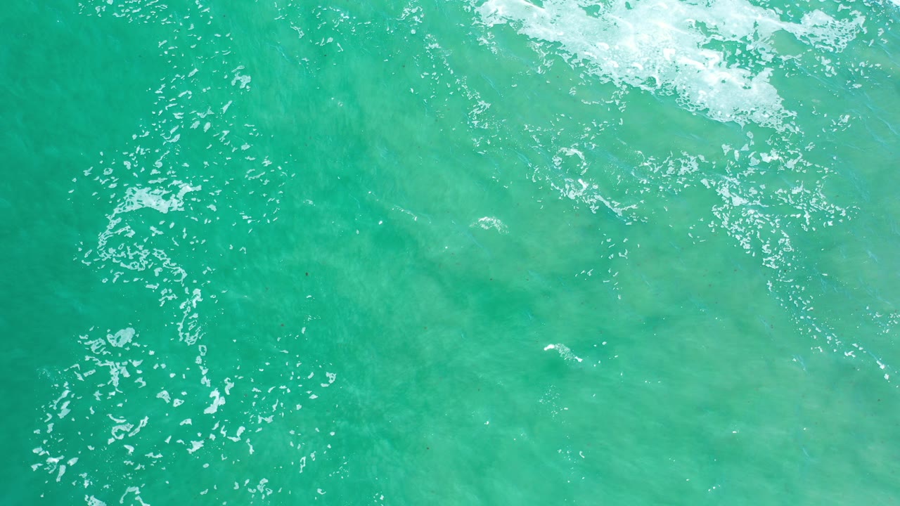 Turquoise water with ripples and white foam near the top edge.