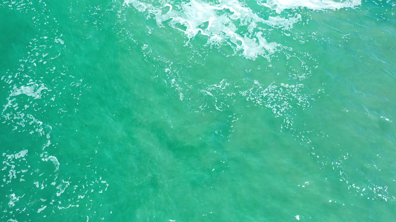 Overhead green ocean water with white foam near the top edge.