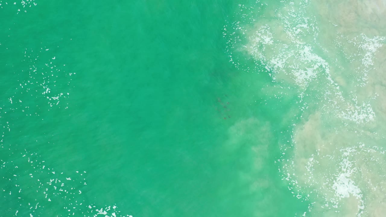 Overhead green ocean with foam and surface glare.