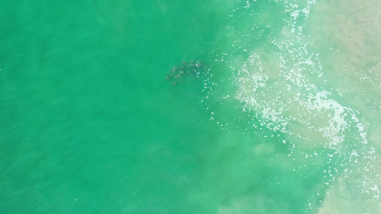 Turquoise green water with foam wash on the right
