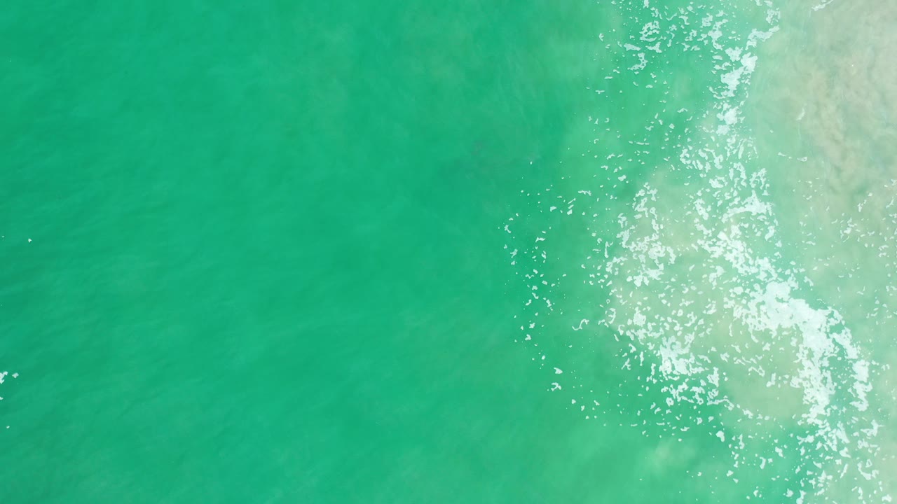 Overhead green-blue water with bright foam and surface sparkle