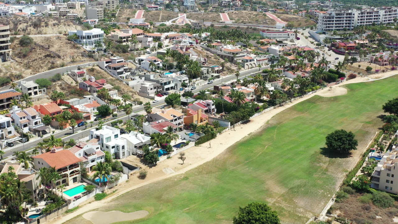 Aerial view of homes beside a green golf course fairway.