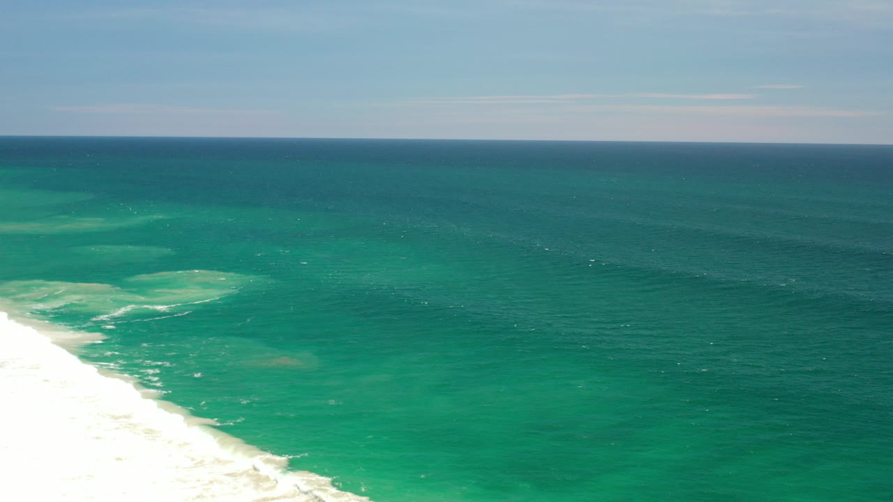 Opening frame of the Los Cabos, Mexico coast showing blue-green water, white surf at the lower left, a level horizon, and no visible people.