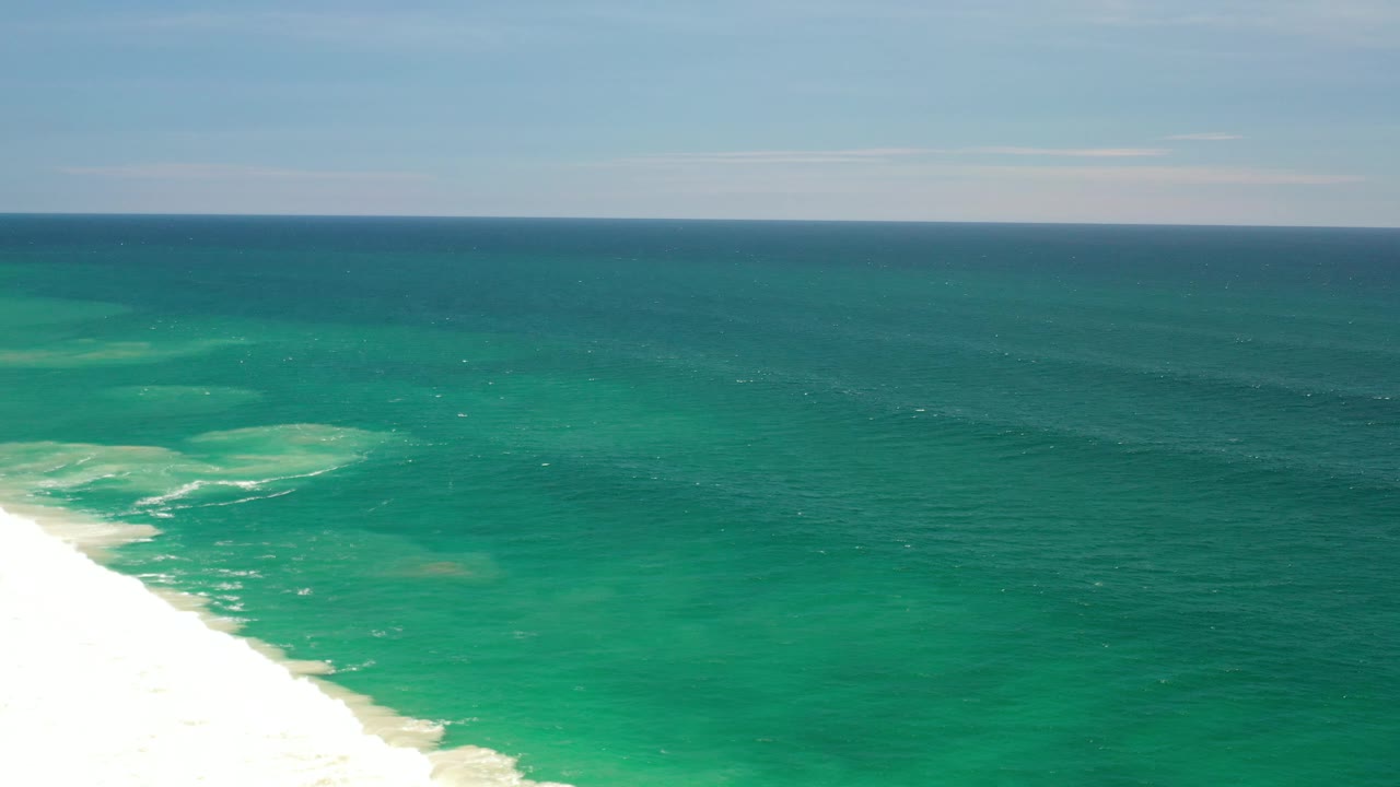 Open blue-green sea with surf line crossing the lower left