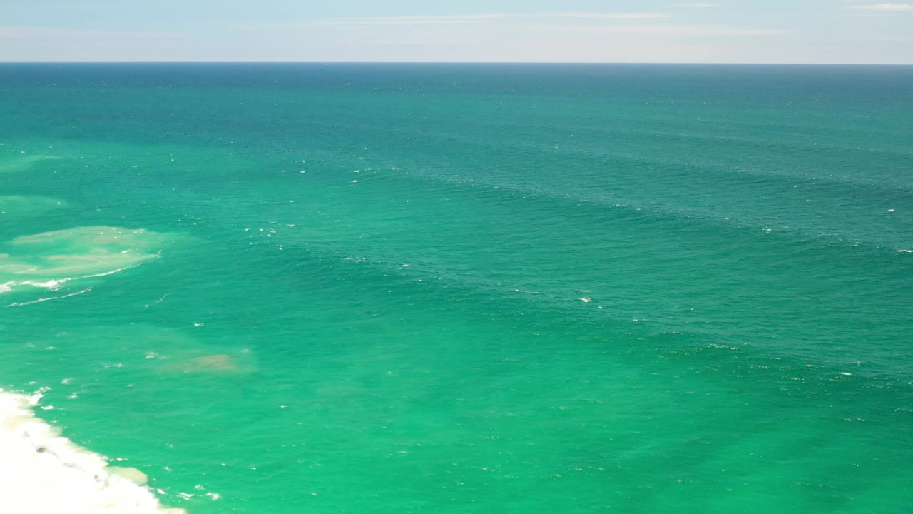 Los Cabos sea surface at 0:01 with the pale underwater patch nearer the center, faint whitecaps across the water, and no visible people.