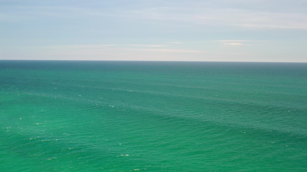 Opening frame of the Los Cabos, Mexico clip showing turquoise ocean stretching to a level horizon beneath a pale sky, with no visible people.