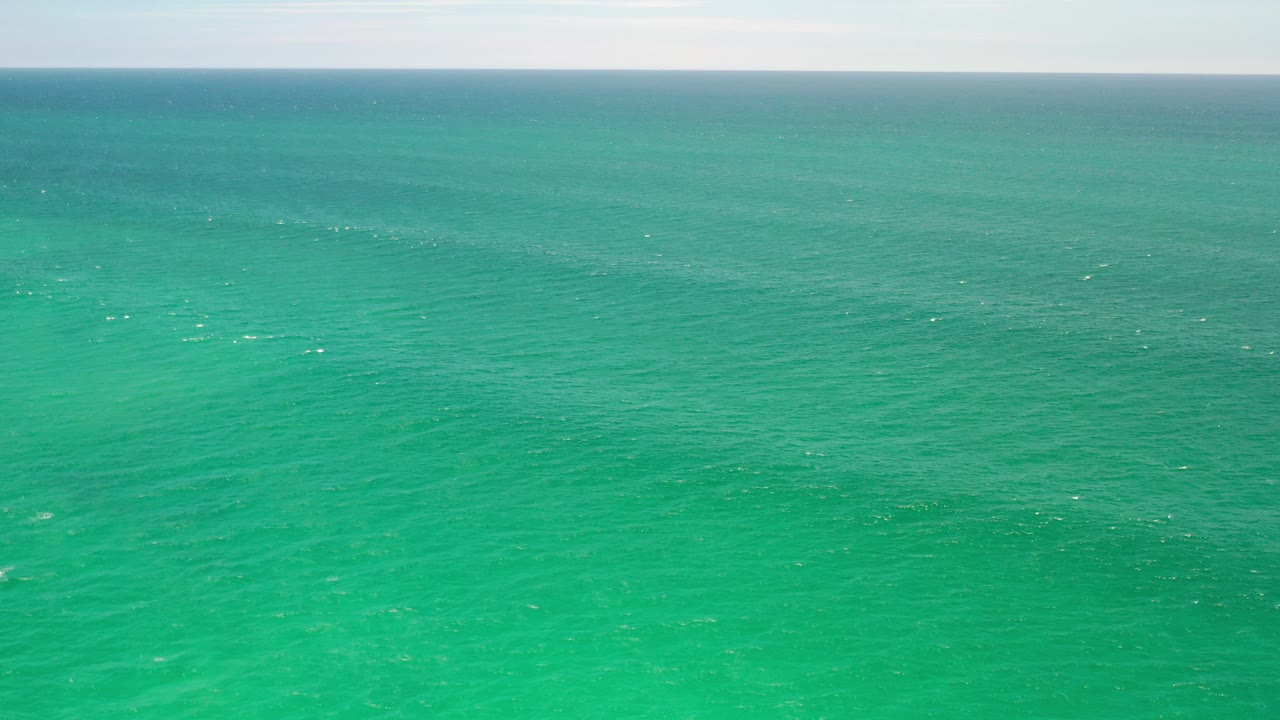 Turquoise ocean beneath a pale sky horizon.