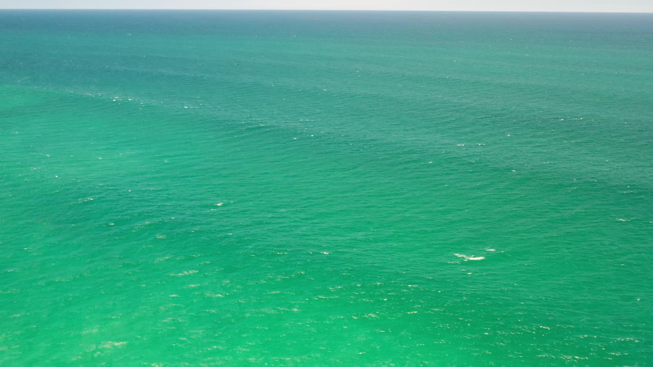 Open turquoise sea with faint ripples and a distant horizon.