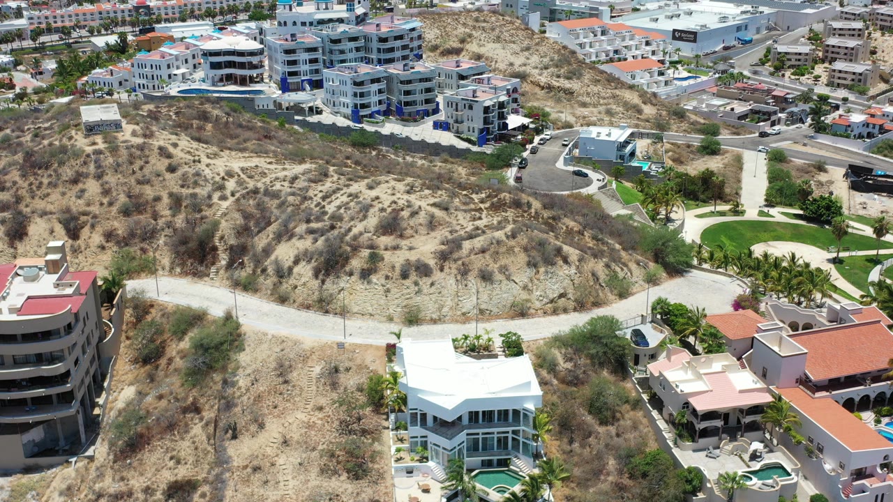 Aerial view of dry hillside with modern buildings and roads.