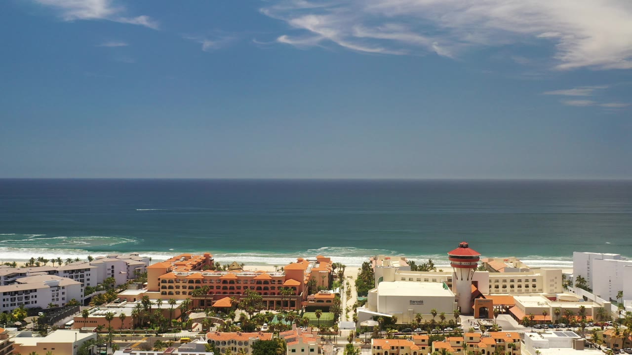 Aerial view of resort-style coastal buildings, beach, and ocean.