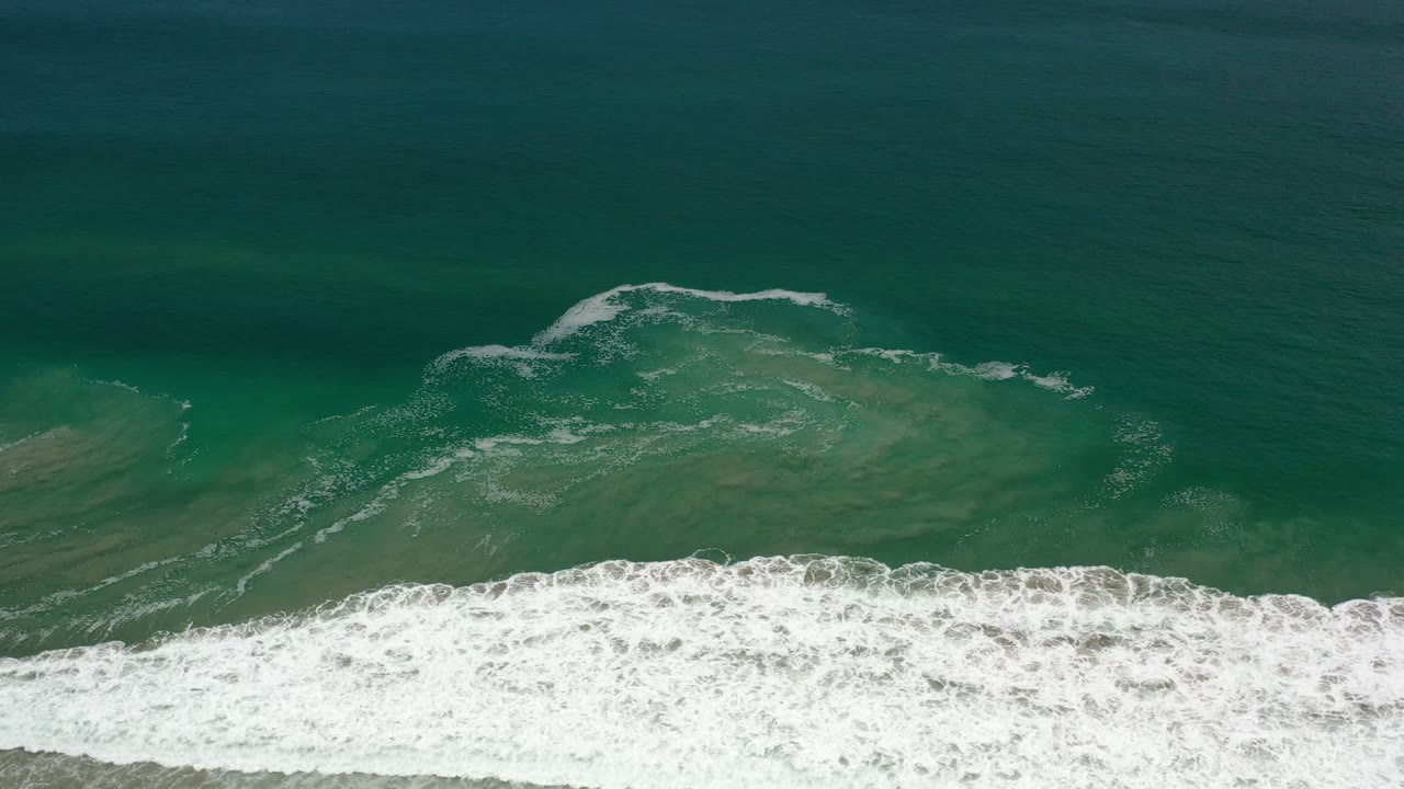 Overhead green ocean water with white surf along the lower edge.