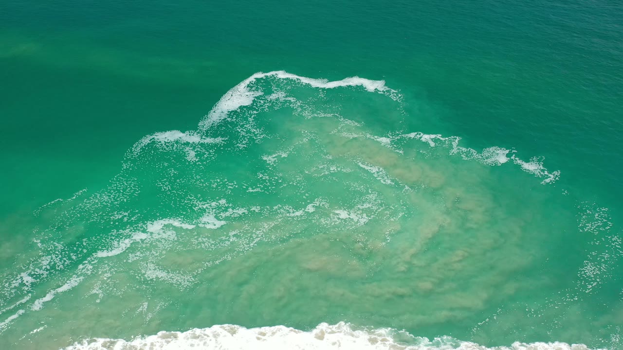 Overhead turquoise seawater with white foam near the top and bottom edges.