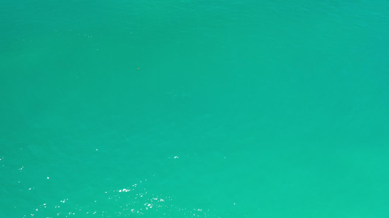 Blue-green ocean in Los Cabos fills the frame with scattered light reflections across the water and no visible people.