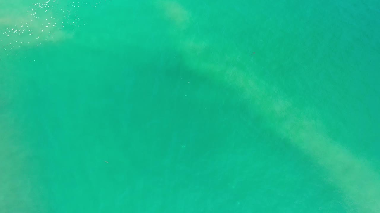 Clear green-blue water in Los Cabos, Mexico, fills the frame with small bright highlights near the upper edge and no visible people.