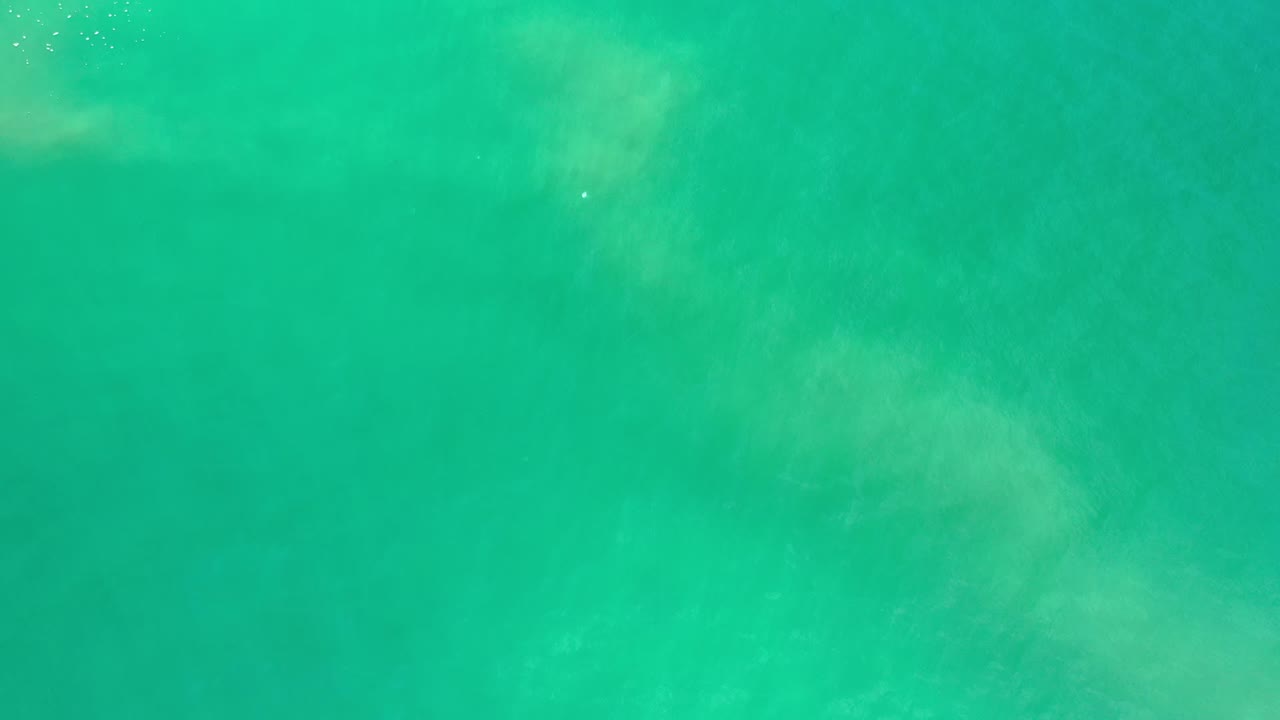 At one second, the Los Cabos water remains an all-over green texture with faint lighter swirls and no visible people or shoreline.