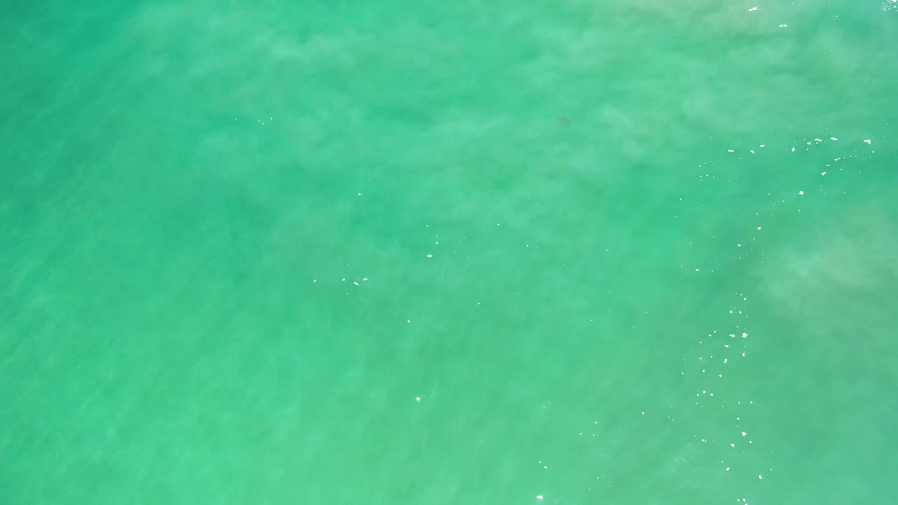 Green water with pale clouded foam patterns.