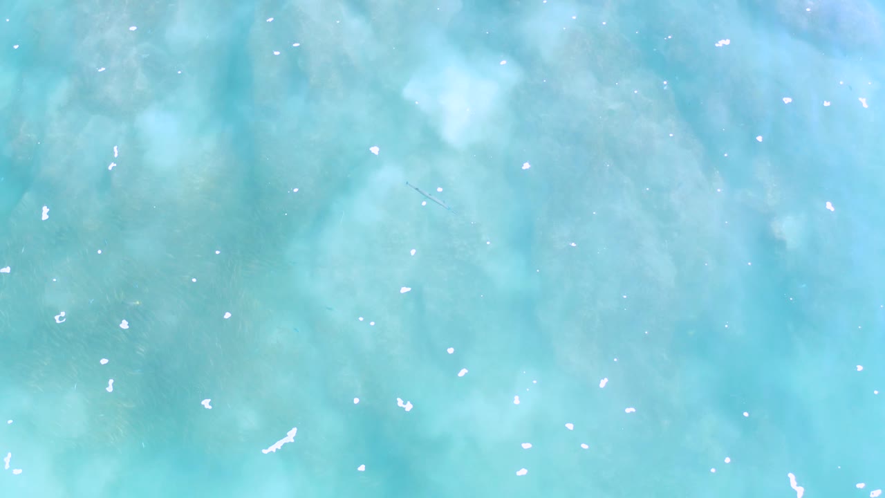 Clear turquoise water in Los Cabos shows pale sparkle and muted underwater texture, with no visible people or shoreline.