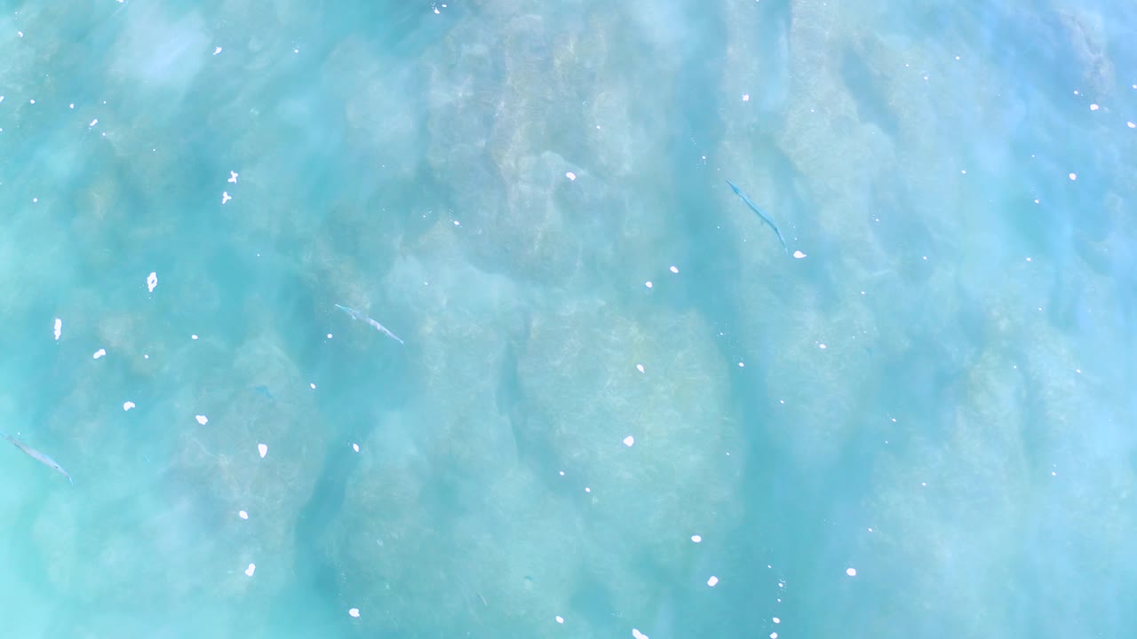 Turquoise ocean surface with pale streaks and white flecks
