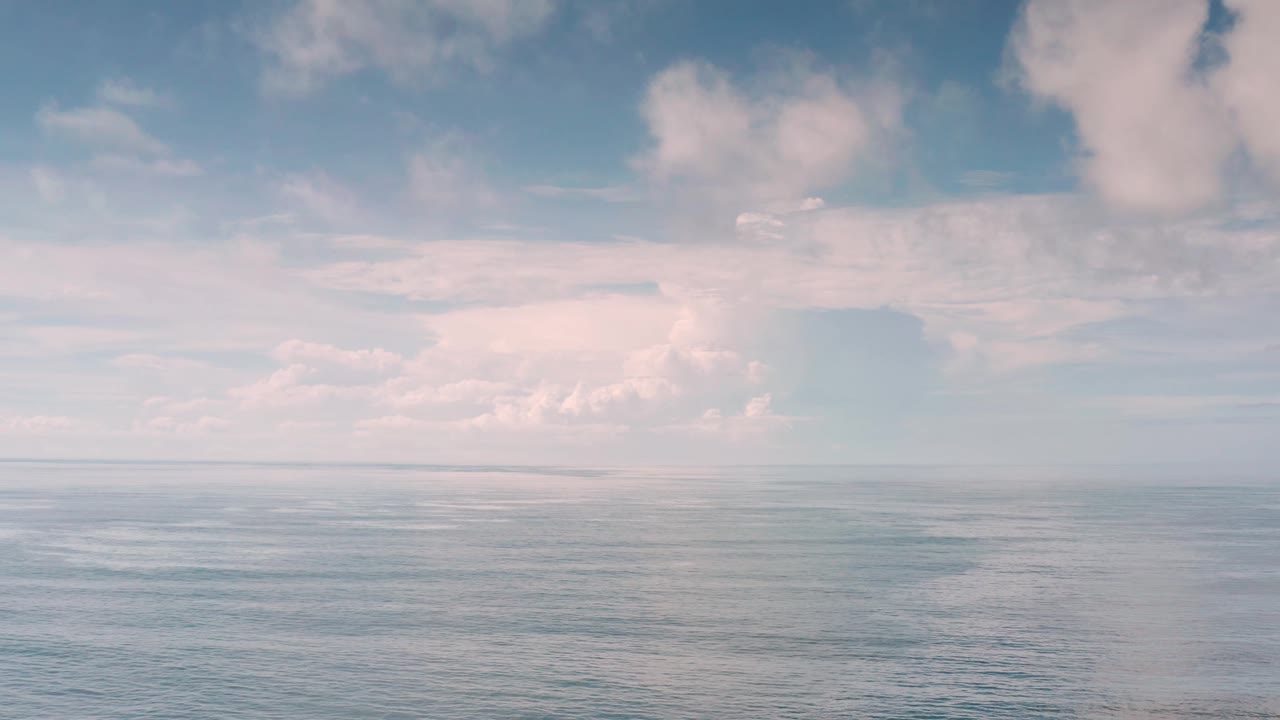 Los Cabos open water sits below a wide cloud band, with the horizon low in frame and no visible people or structures.