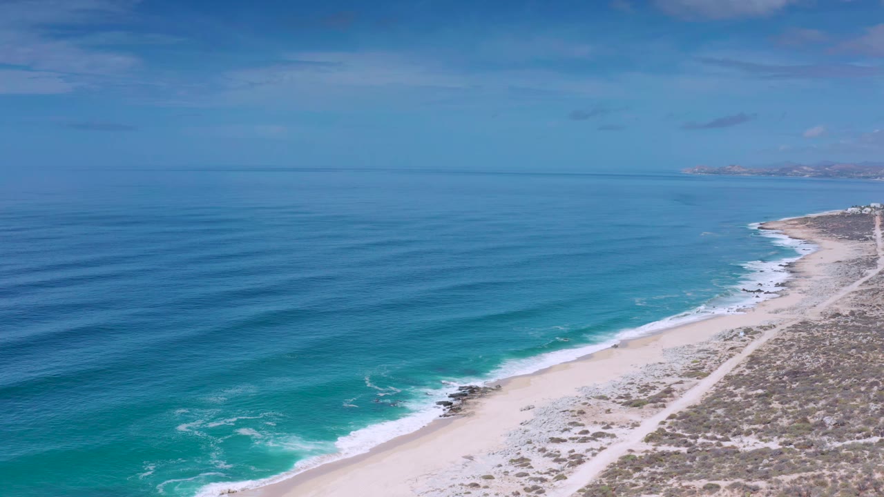 Drone view of turquoise surf and sandy coastline