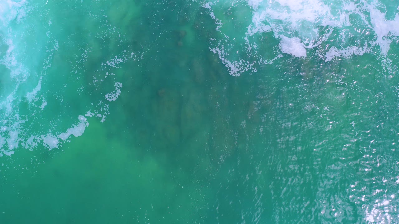 Overhead turquoise ocean with white foam near the top edge