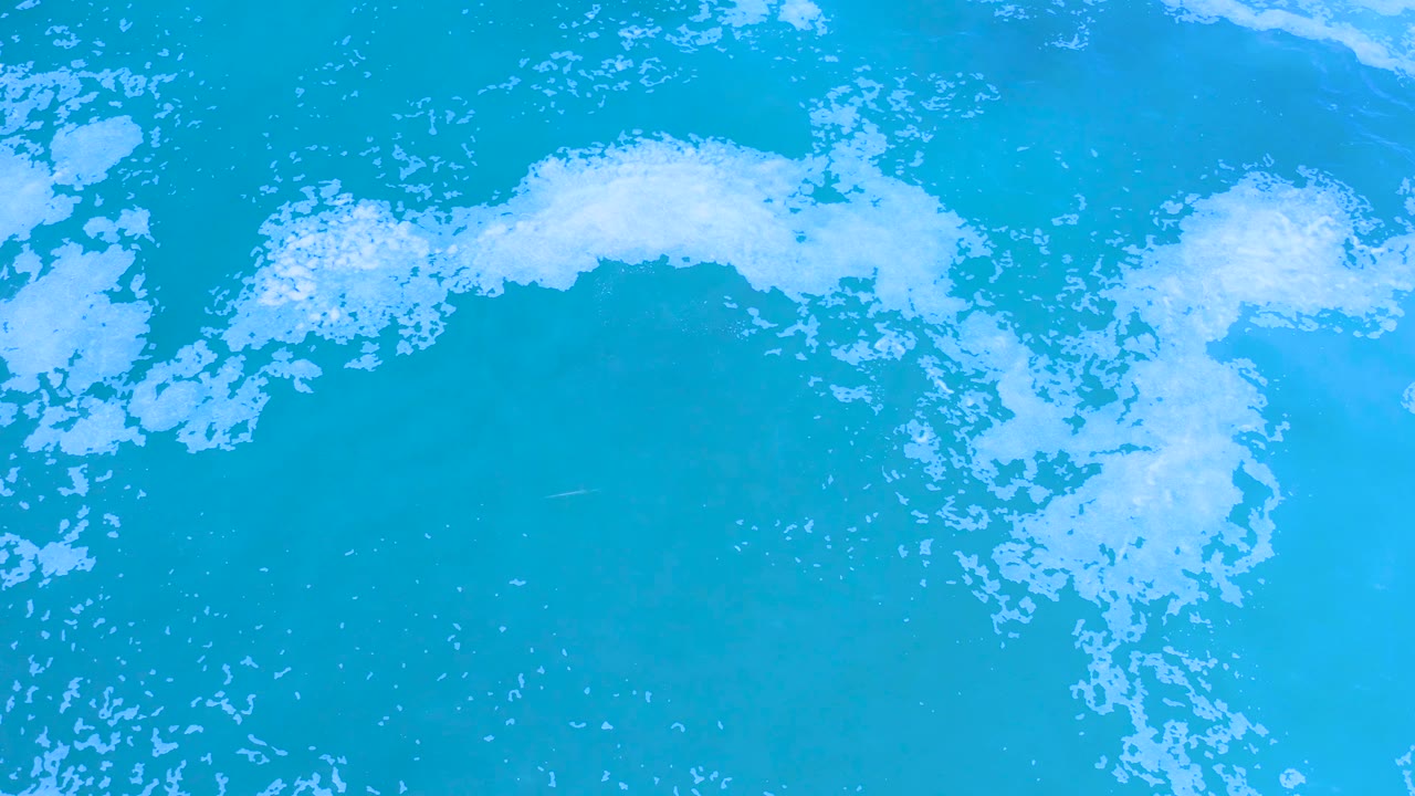 White foam patch over bright blue ocean water