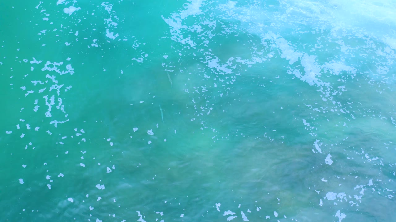 Clear turquoise water with a pale foamy band near the top.
