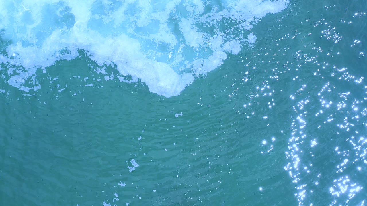 Overhead turquoise ocean with white foam near the top edge