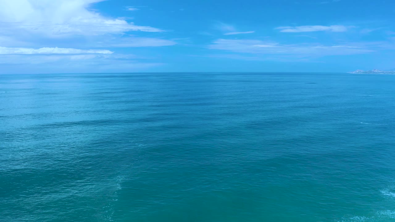 Calm blue water and clouded sky over a distant horizon.