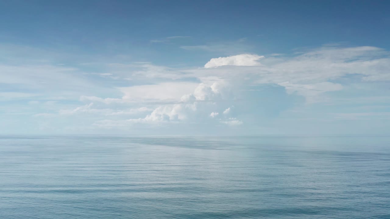 Los Cabos ocean water sits under a broad white cloud bank, with the horizon centered and no visible people.