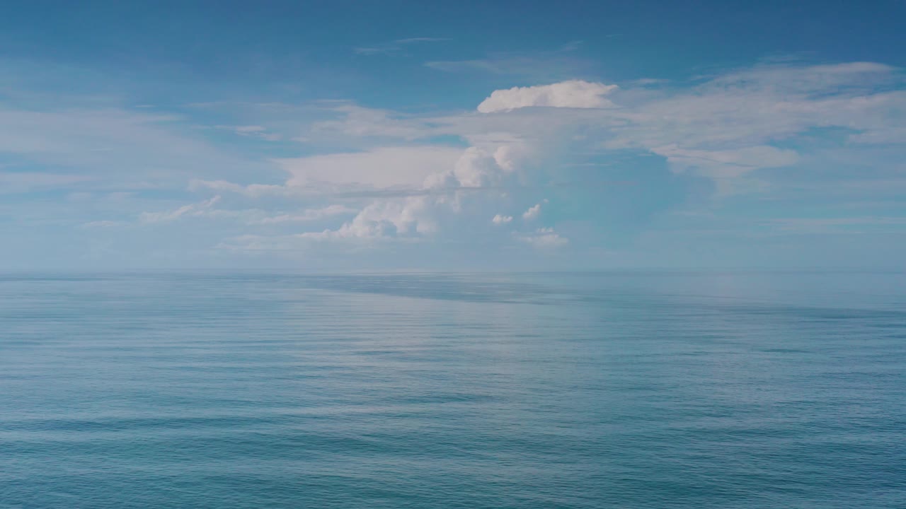 Opening frame of the Los Cabos, Mexico clip showing open blue water, a level horizon, white cloud banks, and no visible people.