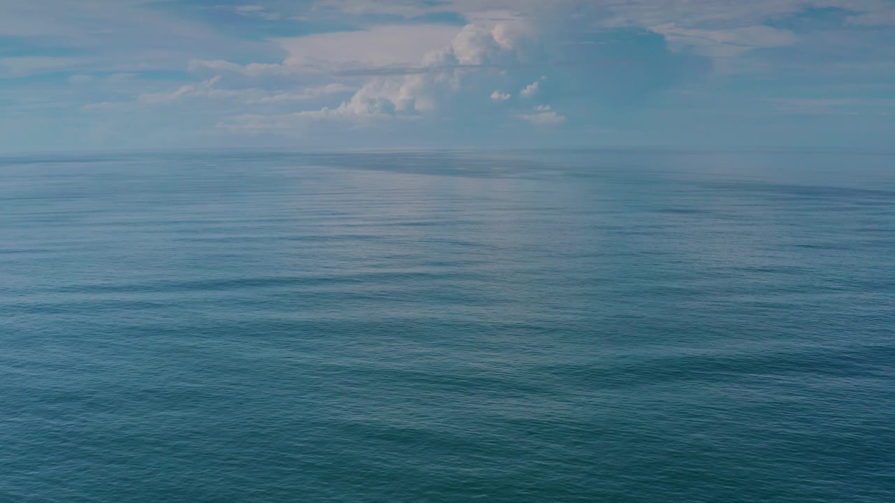 Calm ocean expanse with clouds near the horizon