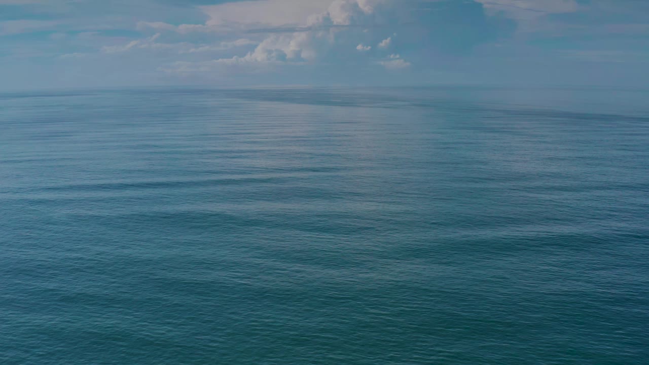 A second view of the Los Cabos ocean surface shows slightly darker blue water below a pale horizon line, with no visible people or vessels.