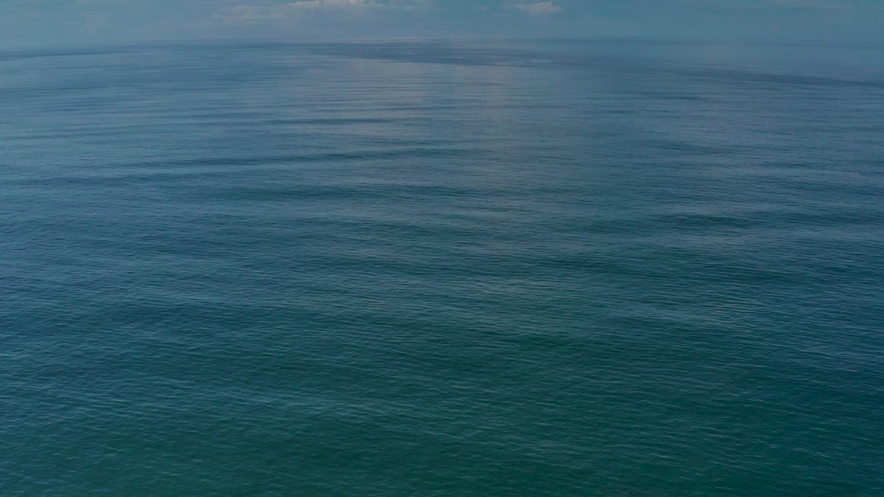 Calm blue-green ocean surface under soft light.