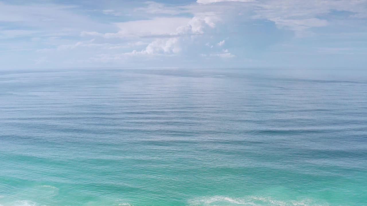 Wide ocean horizon with clouds and turquoise water