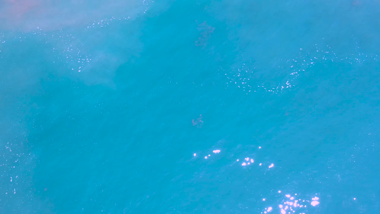 Blue ocean surface with small sun sparkles