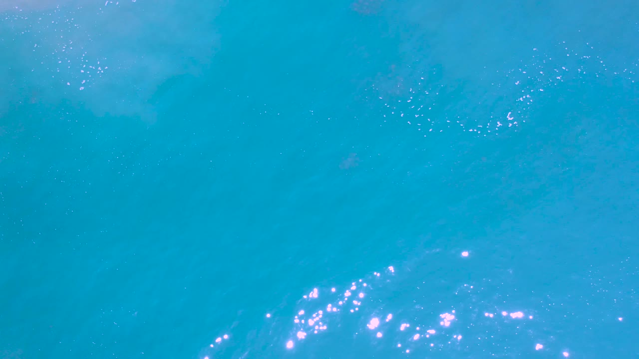 Ocean surface with bright reflections near the lower left