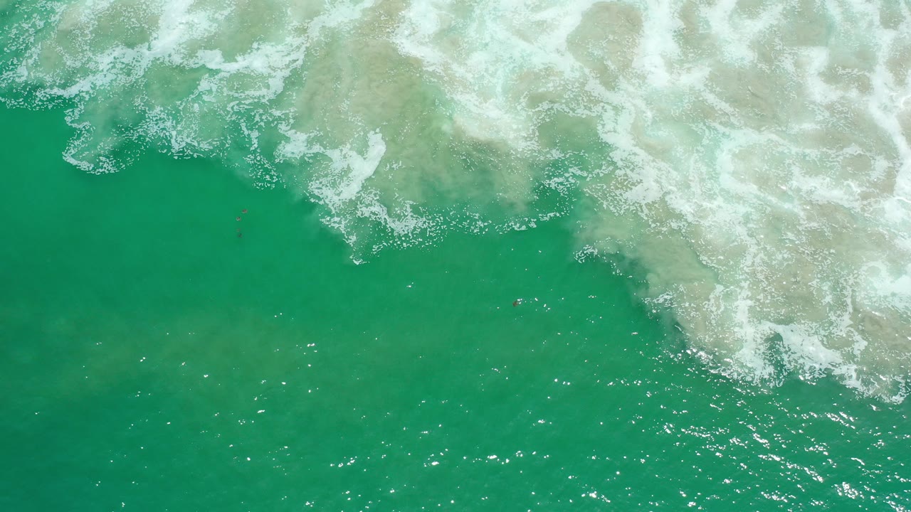 Overhead green water with white foam entering from the top.