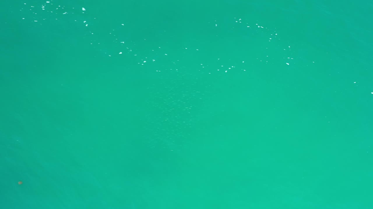 Los Cabos frame with a smooth blue green field, a few white specks near the upper area, faint darker areas, and no visible people.
