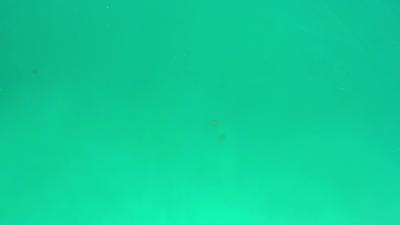 Turquoise open water in Los Cabos, Mexico, shows faint darker areas under the surface and no visible people.